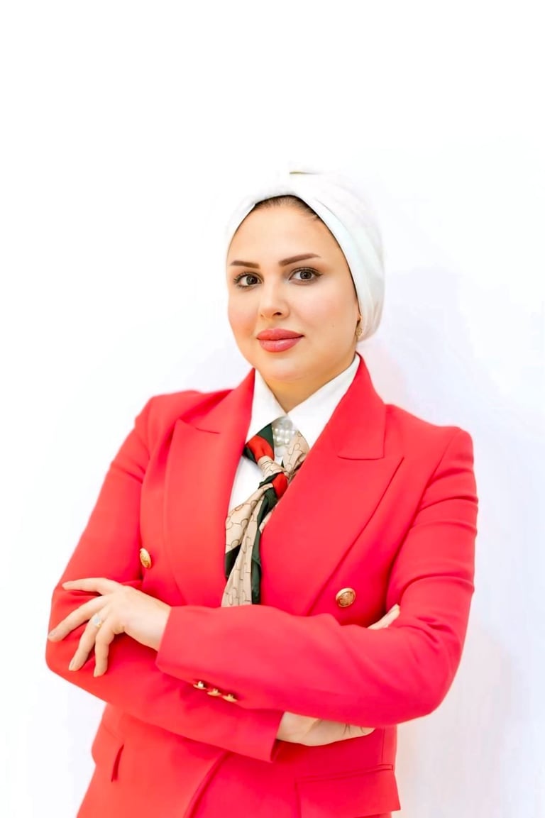 Woman in bright red blazer and white hijab posing with arms crossed against white background