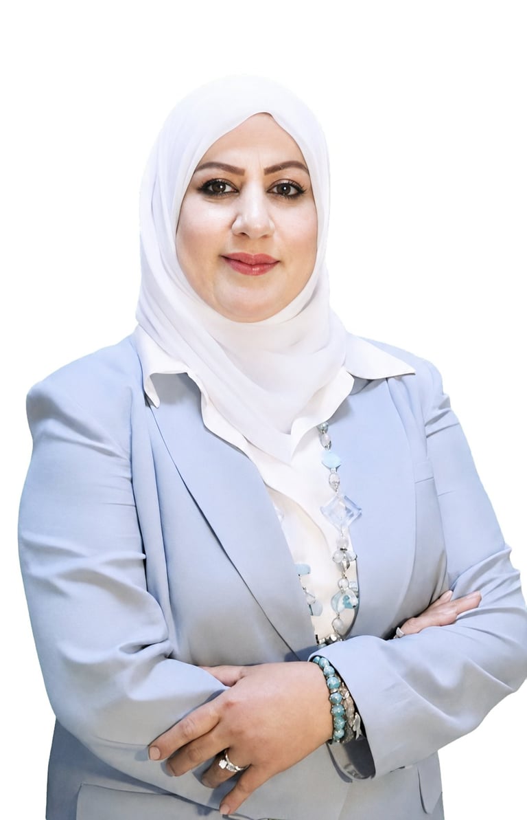 Professional headshot of a woman wearing a white hijab and light blue blazer, arms crossed, smiling at camera against white background